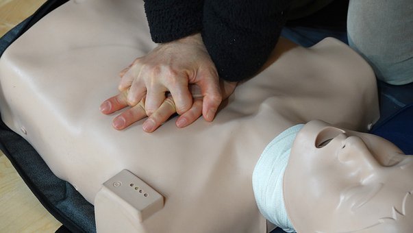 A health professional is showing how to perform CPR, if someone gets cardiac arrest.